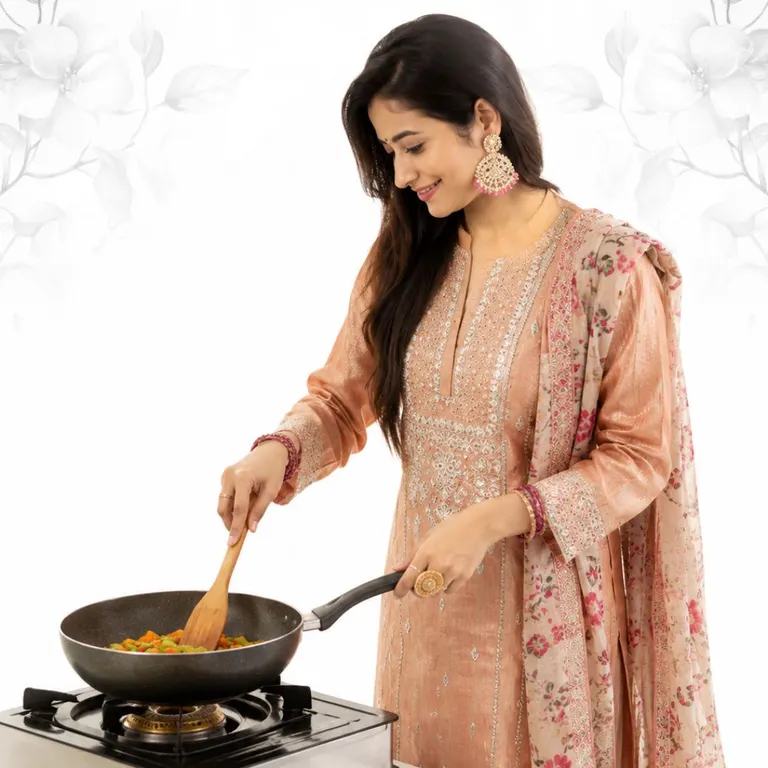 A woman cooking at a stove in a bright kitchen